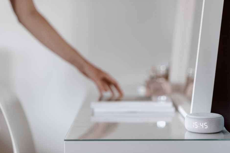 Een moderne woonkamer met slimme apparaten zoals een robotstofzuiger en slimme verlichting.